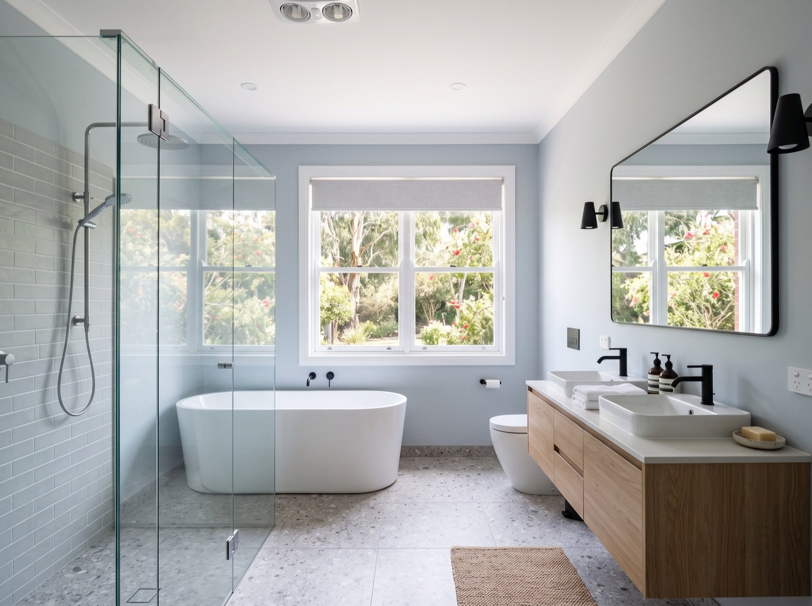 Completed bathroom renovation with terrazzo-look floor tiles and a freestanding bath
